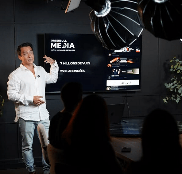 Greenbull Media Axel Hutin, co fondateur de Greenbull Média en chemise blanche, présente sa nouvelle société dans un studio avec des lumières.