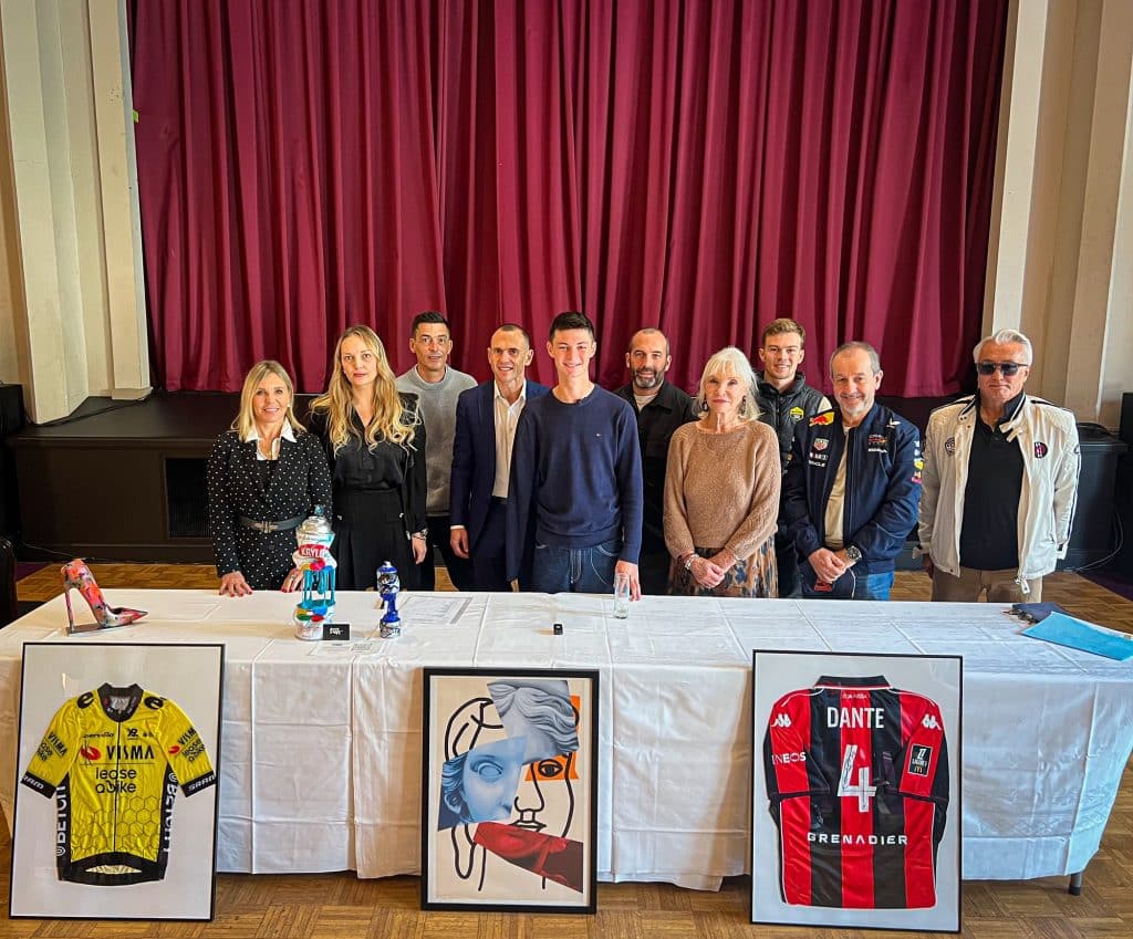 Nathan Mesiano au milieu des différents soutien pour son projet de mini transat 2027. Plusieurs œuvres dont un maillot de l'OGC Nice football et de la Visma Lease a bike en cyclisme son encadrés.