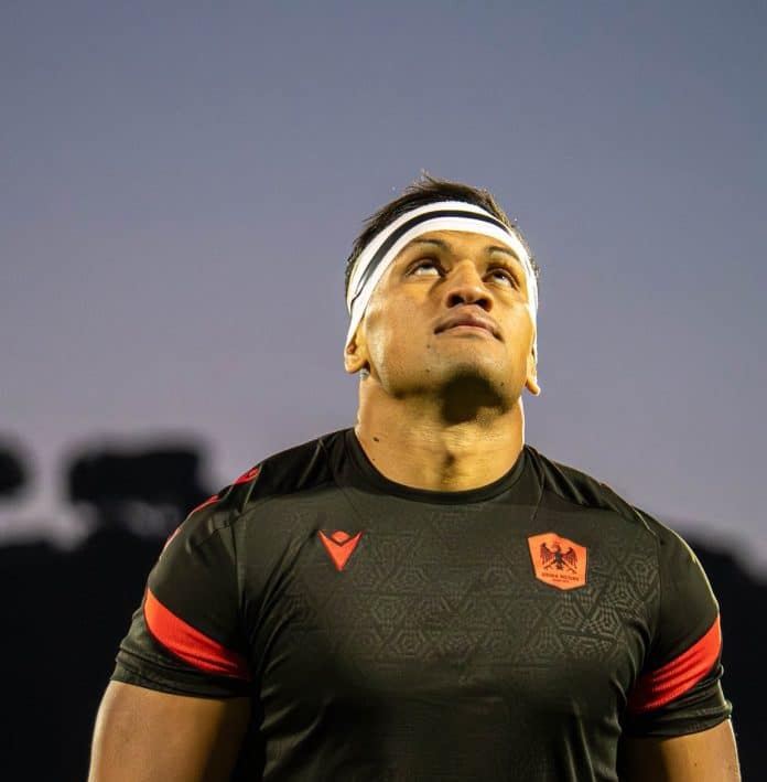 Un joueur de Nissa Rugby en tenue noire regarde vers le ciel.