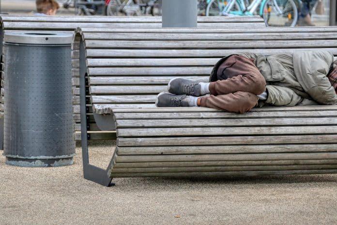 Sans domicile Fixe SDF Une personne sans domicile fixe allongée sur un banc.