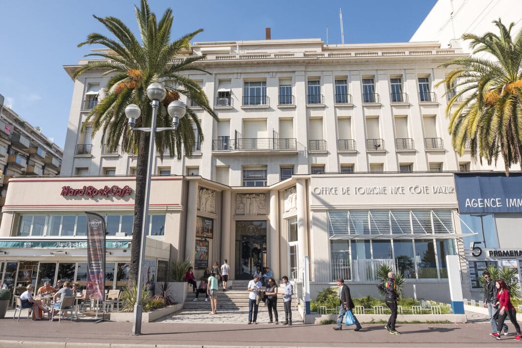 Le bâtiment de l'office de tourisme sur la Promenade des Anglais face à la mer. Il est collé à d'autres bâtiment dont l'ancien Hard Rock café.
