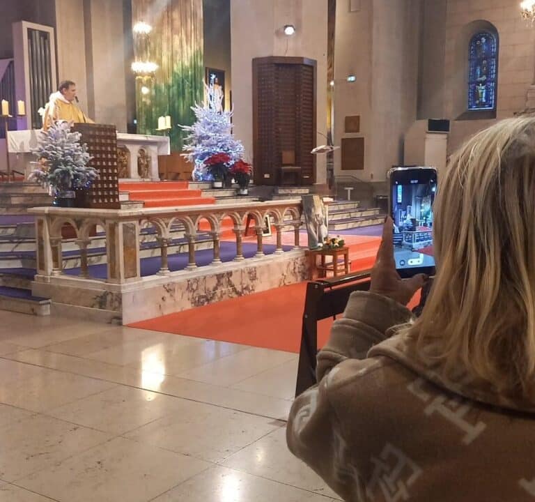 Une personne prend une photo de la messe hommage à Brigitte Bardot dans l'église.