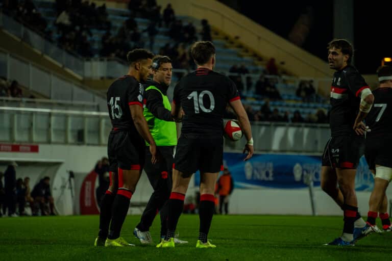 Des joueurs de Nissa Rugby discutent sur la pelouse.