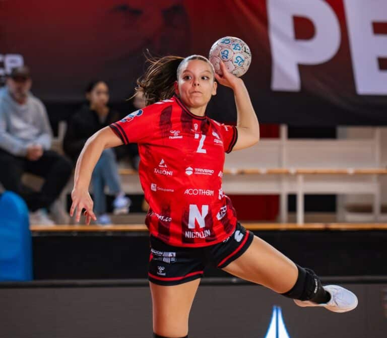 Une joueuse de l'oGC Nice Handball saute ballon en main avant de tirer au but.