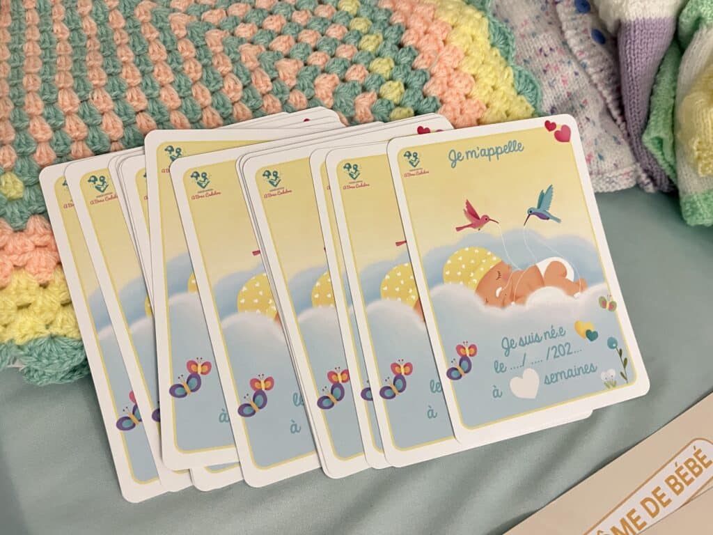 Les kits de naissance avec des jeux de cartes, des vêtements pour enfants de diverses couleurs.
