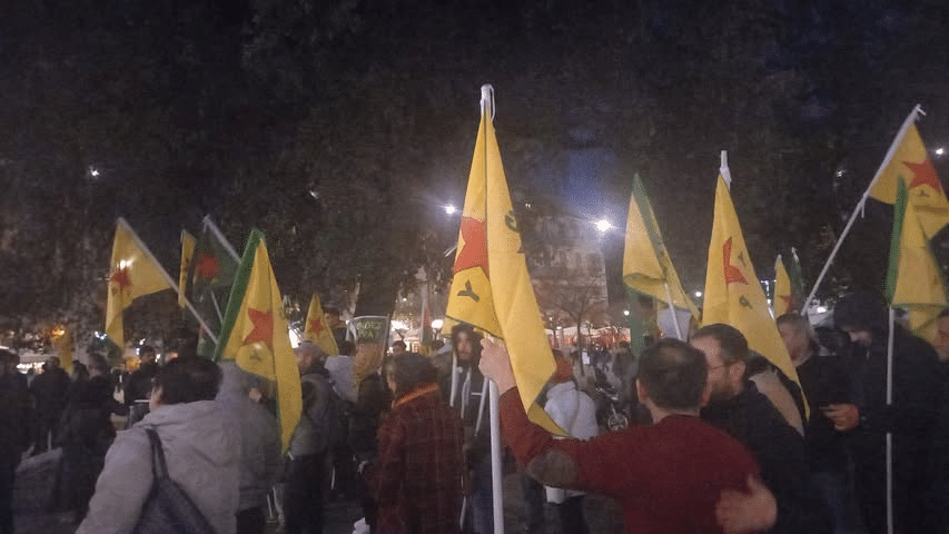 The gathering organized by the PCF06 in support of the Kurdish people on the Place Garibaldi at night with a hundred people and flags waving from the PCF and in support of the Kurdish people.