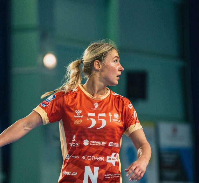 Une joueuse de l'OGC Nice handball avec sa tenue du carnaval de Nice avec un rouge moins intense qui tire vers le orange.