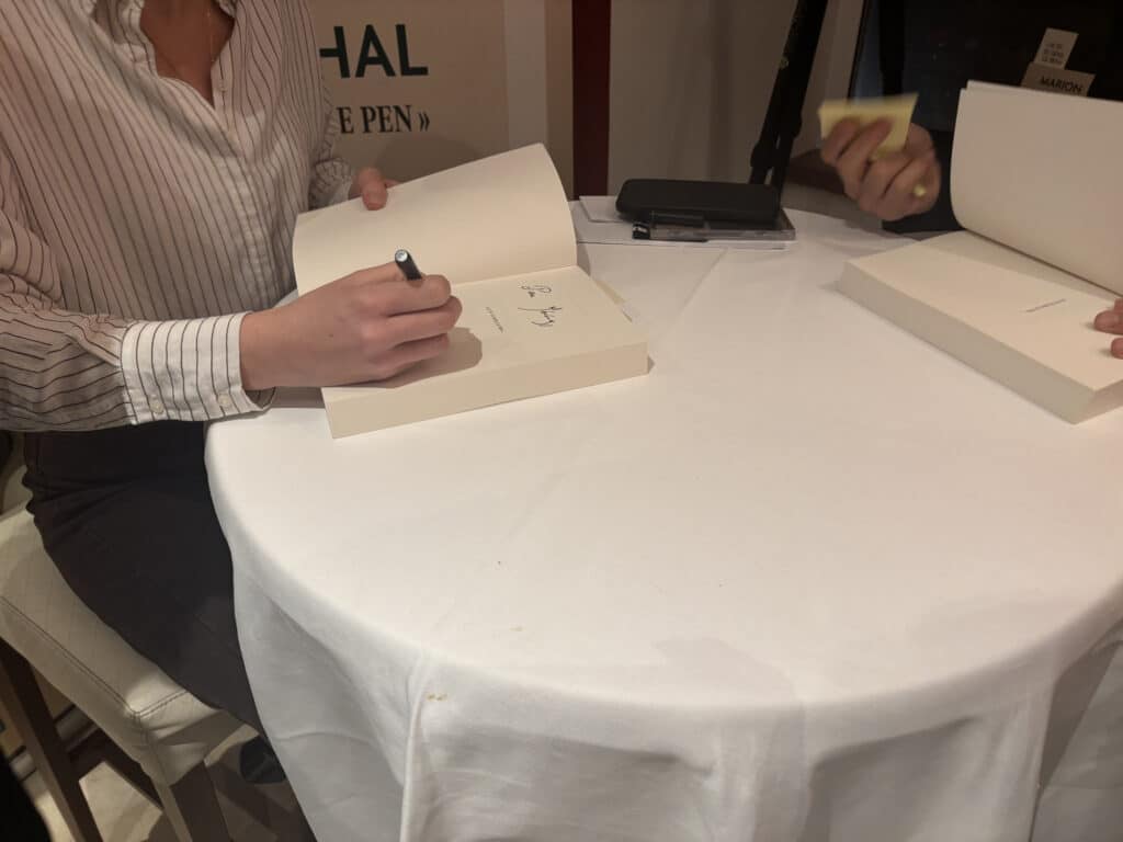 Marion Maréchal, dédicaçant un livre.