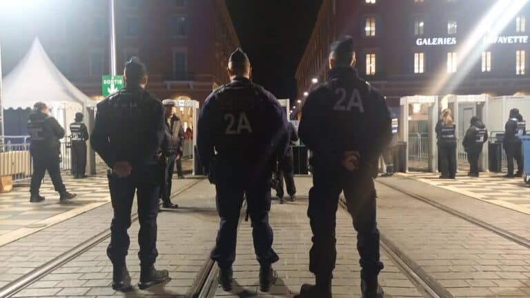 Trois hommes des forces de l'ordre de dos qui attendent que les visiteurs rentre pour le carnaval