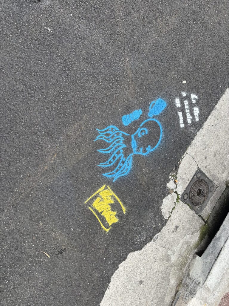 The students invested the street in front of their school by creating drawings to raise passersby awareness. This one shows an octopus with the phrase "the sea needs us"