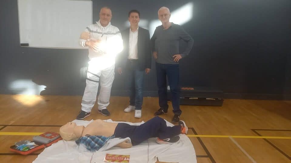 trois hommes sportif, infirmier et medecin qui posent devant un mannequin au sol