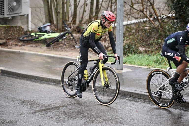 Le coureurs Danois Jonas Vingegaard avec un cuissard long noir et son casque rouge, sur son vélo de route en train de rouler.