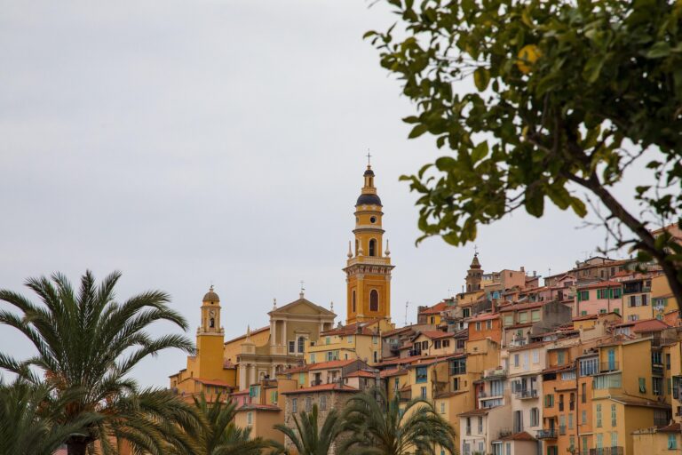 La ville de Menton avec ses maison en couleur jaune, rose, orange et blanches.