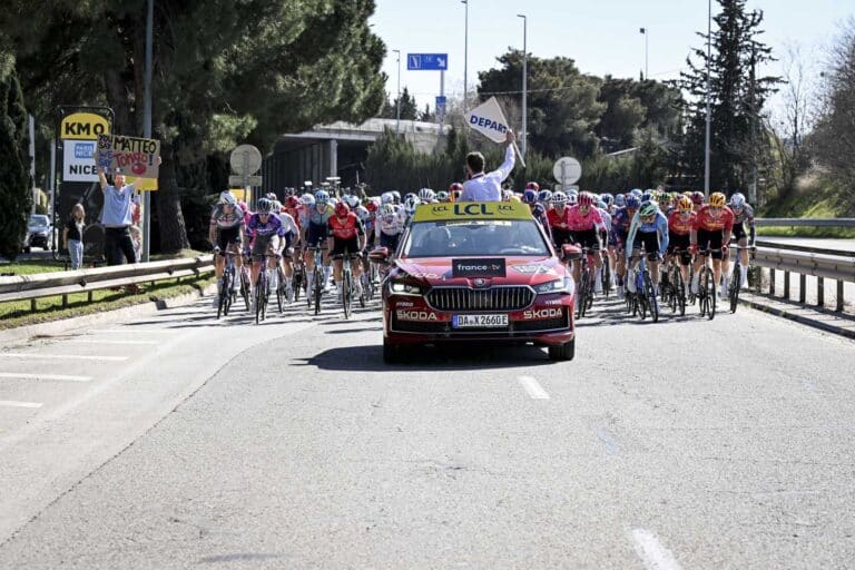 Les coureurs de Paris-Nice avant le départ derrière la voiture du directeur de course qui agite son drapeau pour donner le départ.