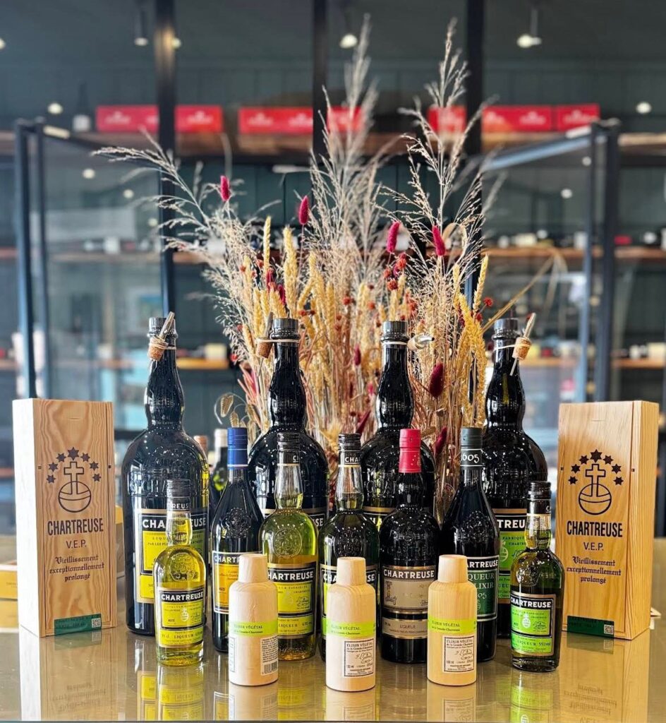 Une série de bouteilles de différentes tailles sur une table blanche dans un décor floral.