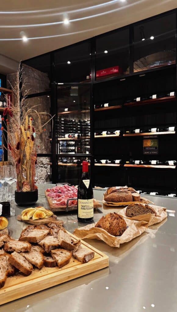 Une bouteille de vin mise en scène avec du pain, de la charcuterie...