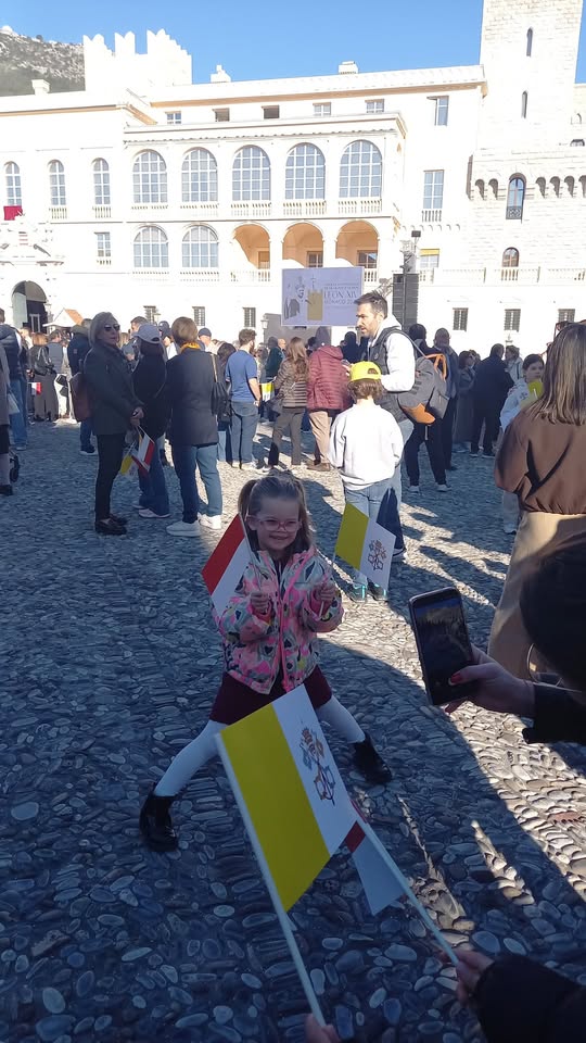 enfant joue avec des drapeaux en attendant le pape place du palais