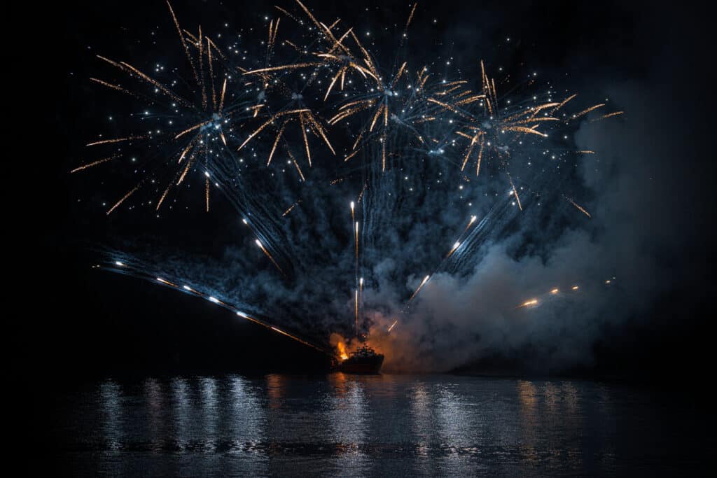 Le feu d'artifice du Carnaval de Nice tiré sur la mer devant la Promenade des Anglais. Une explosion de couleurs bleu.