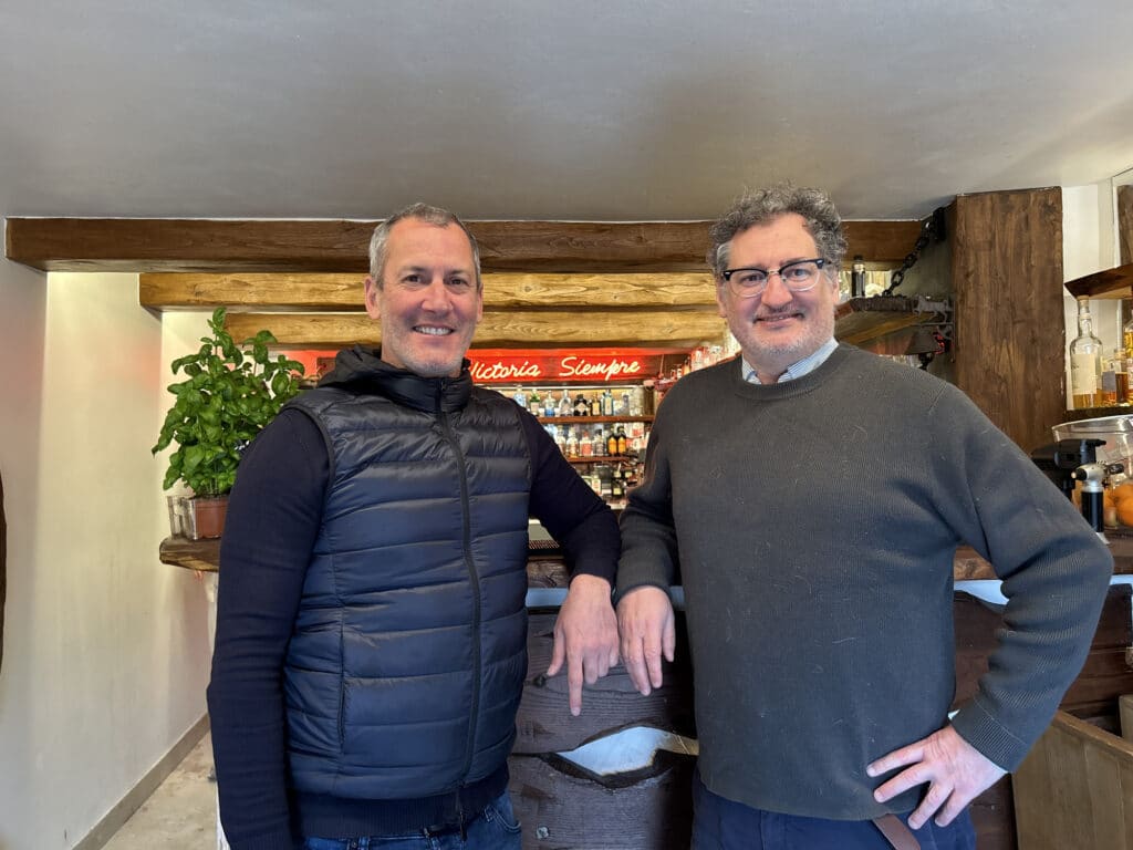 le directeur et le gérant se tenant fièrement devant le bar