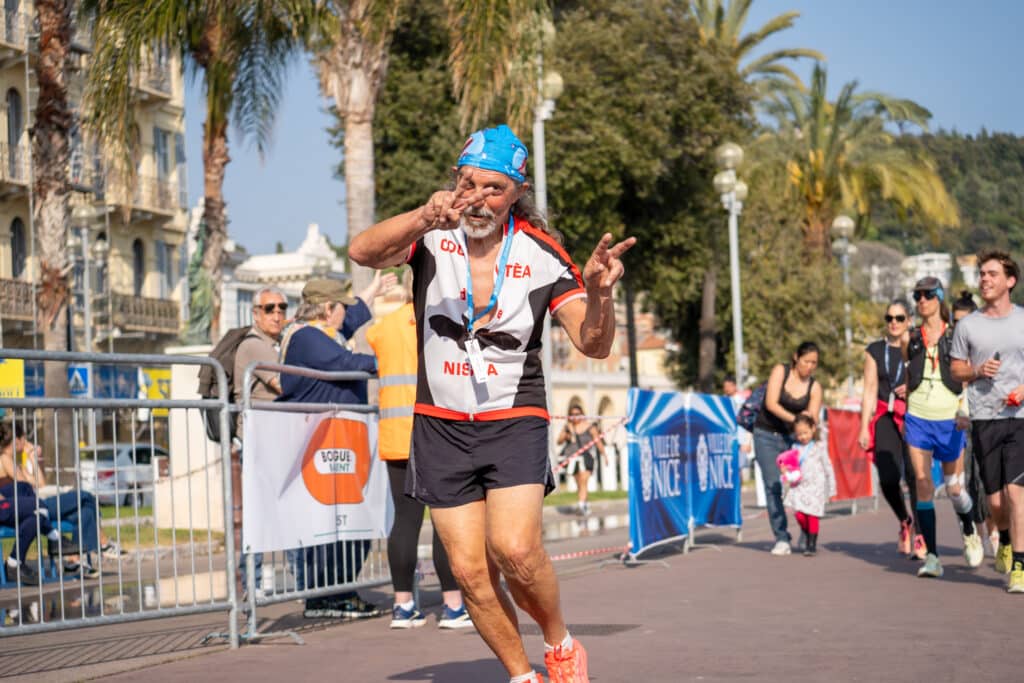 Un participant de la No Finish Line de Nice 2026 fait un signe au photographe.
