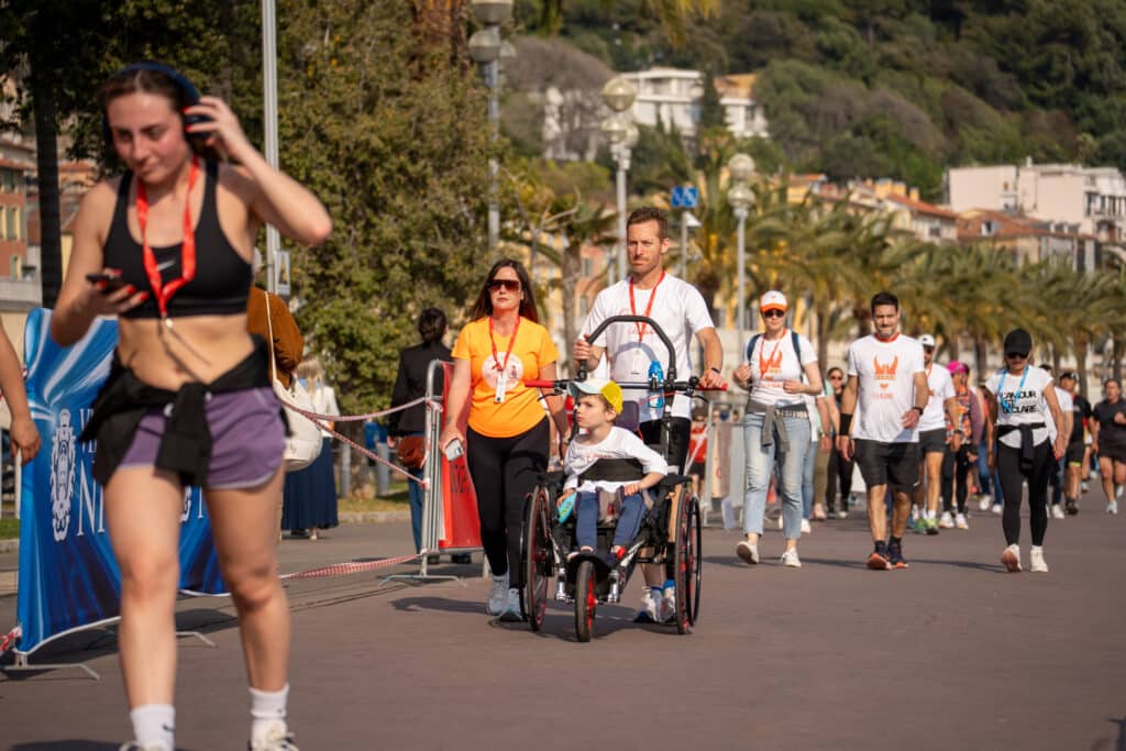 Des parents avec leur enfant dans une poussette lors de la No Finish Line 2026 de Nice.
