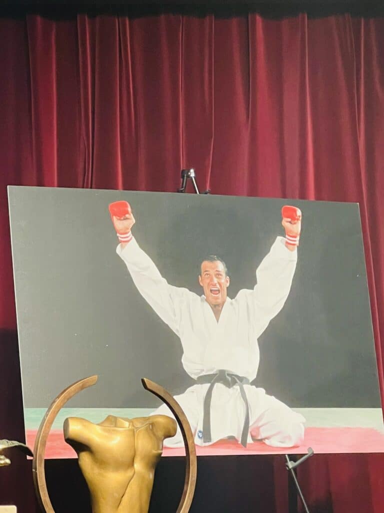 Le champion de Karaté niçois, Christophe Pinna en photo sur une toile levant les bras après son succès au championnat du monde de karaté.