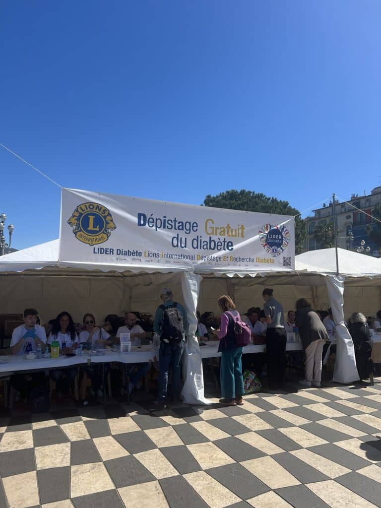 The stand of the LIDER Diabetes initiative at Masséna Square with people behind tables under a large white tent.