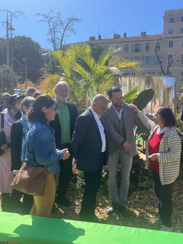Eric Ciotti talking with residents alongside elected officials amid the vegetation installed on the Promenade du Paillon.