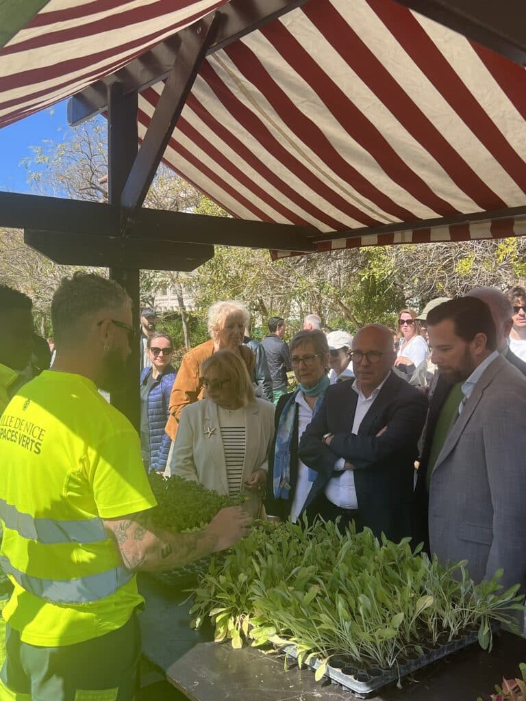 Eric Ciotti talking with an agent in front of a stand.