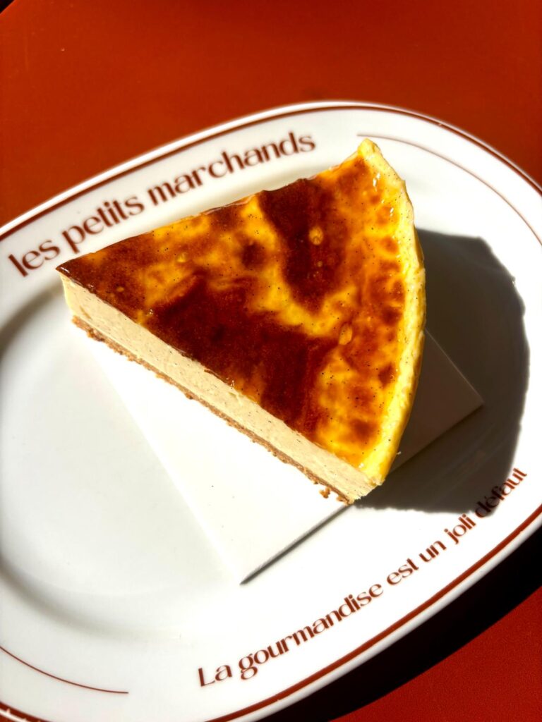 Pâtisserie Les Petits Marchands : pâte sablée amande / crémeux dans une assiette au nom de la pâtisserie