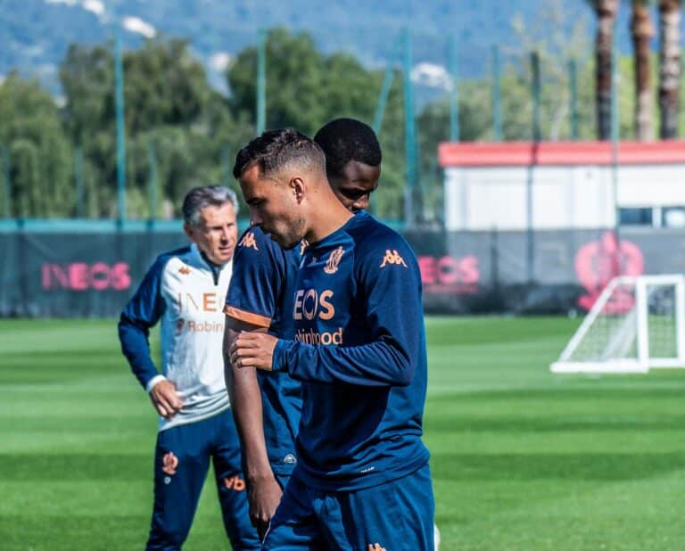 Les joueurs de l'OGC Nice en survêtement bleu avant de démarrer leur entrainement avec le coach Claude Puel en arrière plan.