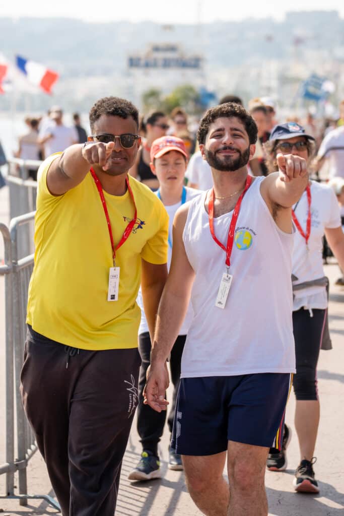Deux participants de la No Finish Line 2026 de Nice pointent le photographe du doigt avec le sourire.