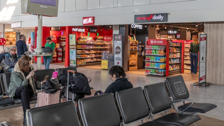 Les nouvelles enseignes dans l’aéroport de Nice avec des passagers dans les boutiques et à côtés.