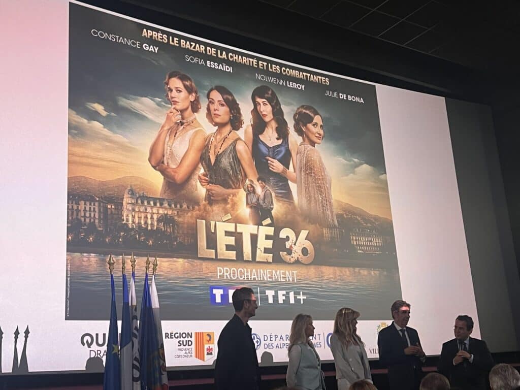 L'affiche de l'été 36 projeté sur un écran de cinéma avec des élus à côté en train de parler.