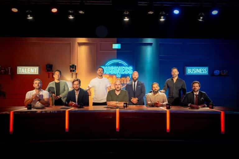 L'équipe de Business ou talent dans le studio avec des couleurs bleu et orange. Neuf personnes sont sur le plateau.