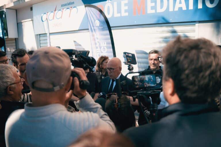 Le maire de Nice Eric Ciotti devant la presse avec de nombreux journalistes autour de lui.