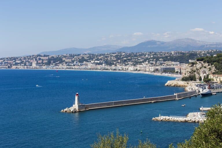 Le port de Nice vue depuis la mer avec un ciel bleu mais légèrement voilé.
