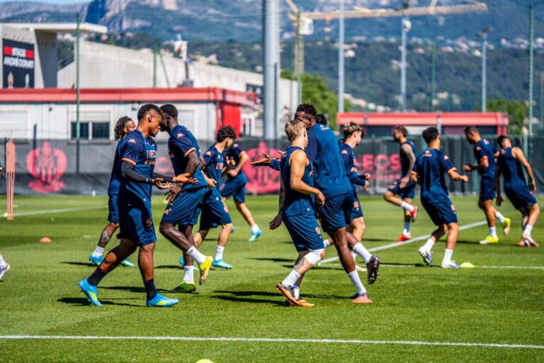 Les joueurs de l'OGC Nice s'entrainent en tenue bleu en trottinant.