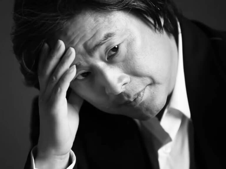Le président du jury du Festival de Cannes park chan-wook prend la pose en posant sa main sur sa tête.