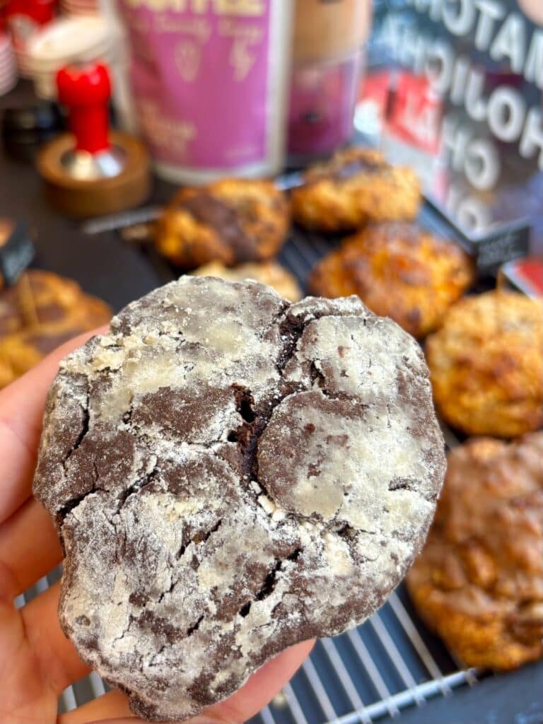Un cookie pas plat au chocolat avec de la poudre blanche sur le dessus.