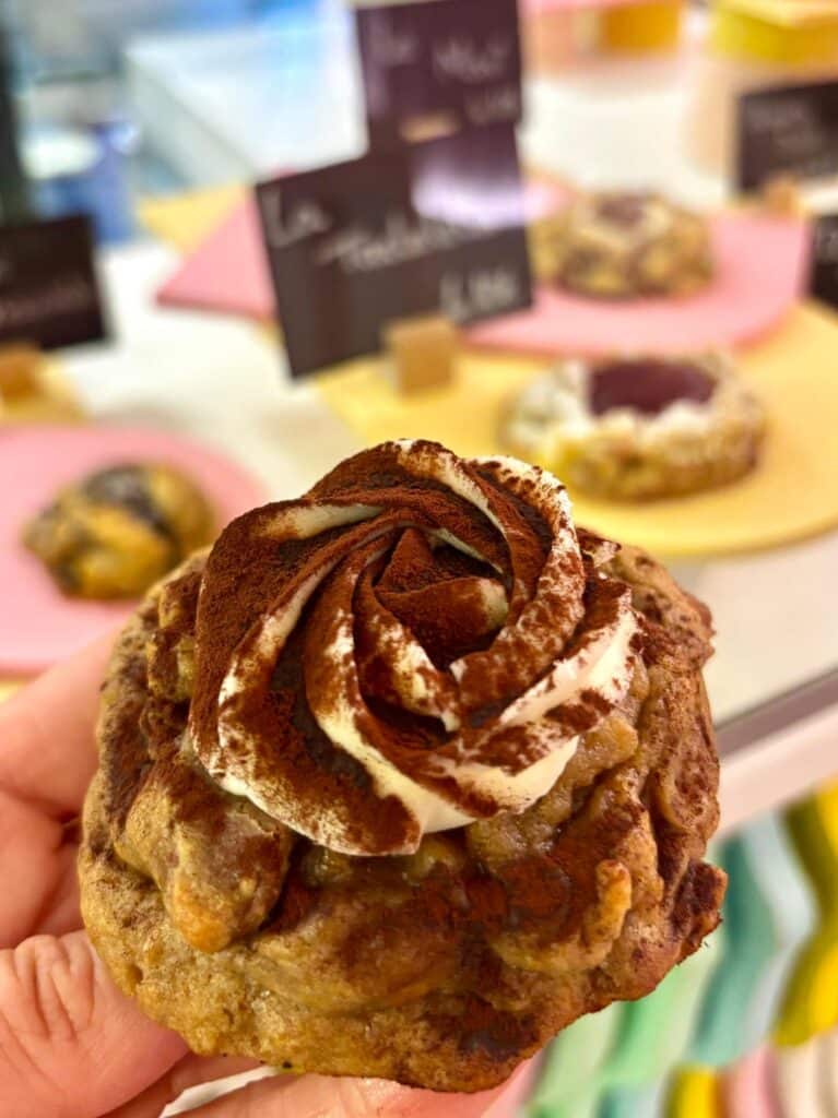Un cookie avec une crème saupoudrée de chocolat en poudre sur une crème tiramisu.