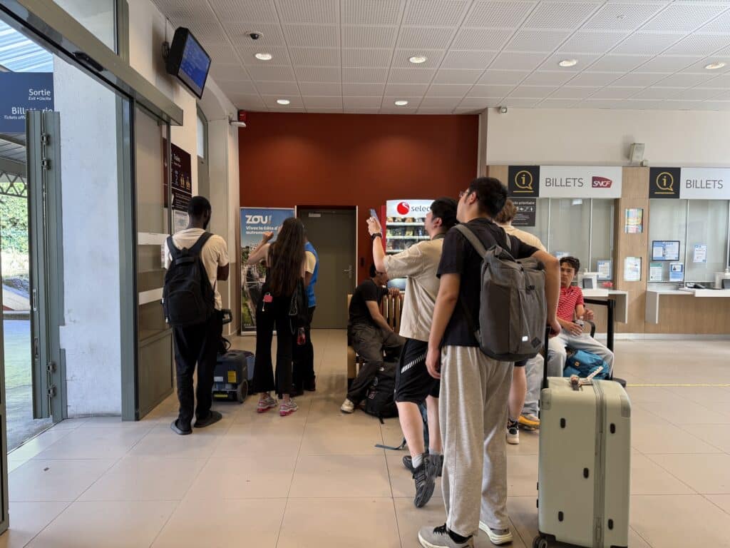 Des passagers consultent le panneau des affichages en gare de Nice Riquier