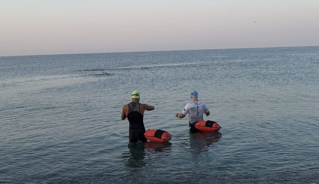 Deux athlètes vont dans la mer pour leur partie natation.