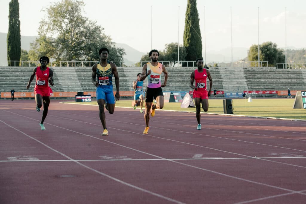 Les athlètes du meeting Nikaïa lors d'une épreuve de sprint en plein effort devant la ligne d'arrivée.