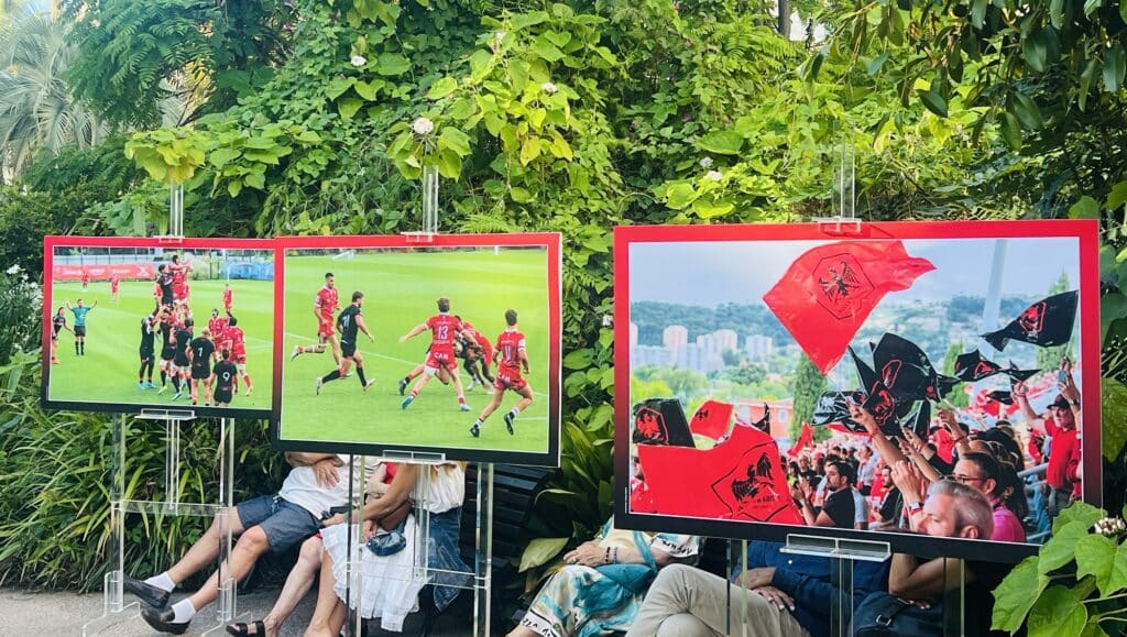 Des photos de match affichées dans le jardin de la villa Massena montrant des moments de match comme un joueur levé sur une touche.