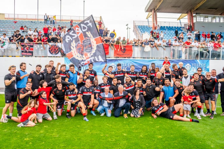 Les joueurs de Nissa Rugby après la montée en Pro D2 avec des drapeaux.