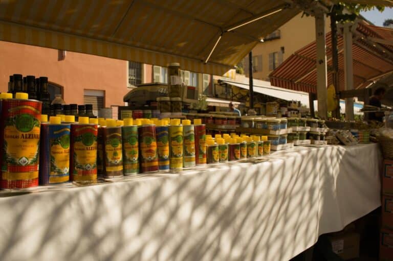 Bottles of olive oil displayed at an outdoor market.