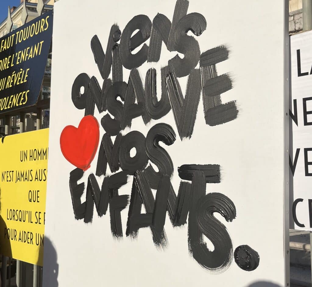 peinture sur laquelle est écrit en noir, suivi d'un coeur, "viens on sauve nos enfants."