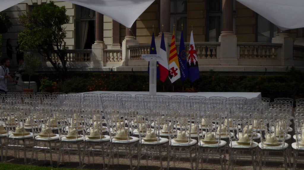 La décoration de la cérémonie avec des chaises blanches devant une estrade.