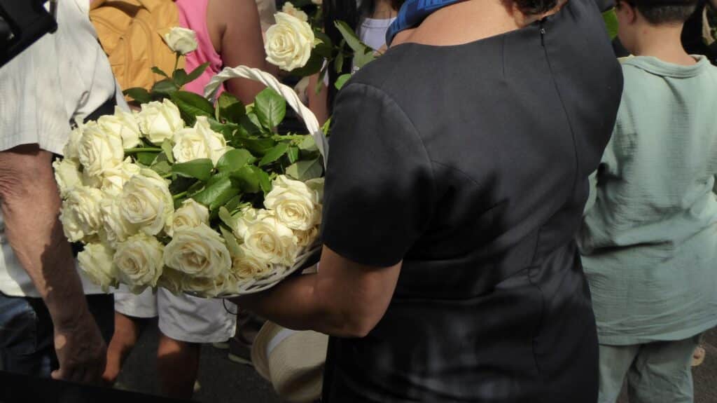 Des fleures blanches portées par des hôtesses habillées en noir.
